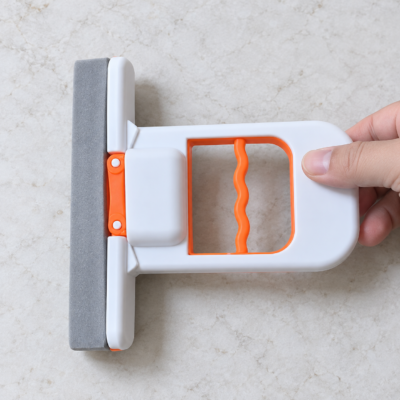 Compact white and orange sponge mop-2 Mini self-squeezing sponge mop being used to remove water from countertop